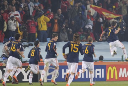 Villa, perseguido por sus compañeros, celebra con algunos  aficionados españoles el primer gol de España.