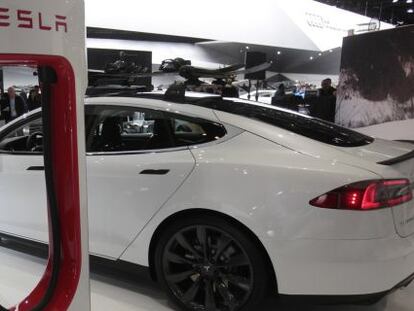 Un Tesla Model S junto a su cargador