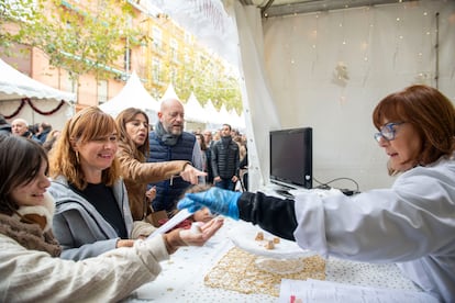 Una tendera ofrece a los clientes para degustar trozos de turrón de Alicante en la Feria de Navidad de Jijona.