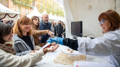 Una tendera ofrece a los clientes para degustar trozos de turrón de Alicante en la Feria de Navidad de Jijona.