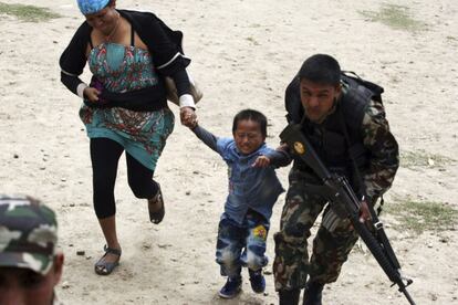 Fotografía facilitada por el ministerio indio de Defensa, que muestra a un miembro de las fuerzas armadas de Nepal ayudando a una madre y a un niño que están siendo evacuados del área afectada por el terremoto en Nepal.