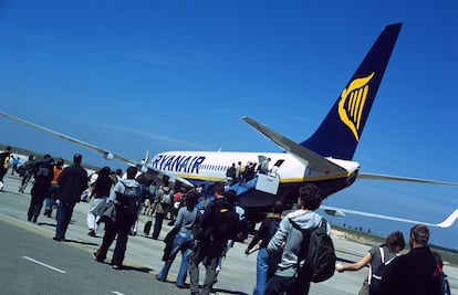 Un grupo de viajeros embarca con su equipaje de mano en un avión de Ryanair.