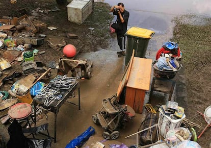 Los residentes de Brisbane comienzan a evaluar los desperfectos causados en sus casas por las inundaciones, mientras desciende el nivel del río. Más de 25.000 viviendas han sido desvastadas por el agua y el lodo y alrededor de 100.000 se han quedado sin electricidad. En la imagen, un hombre fotografía los muebles y objetos embarrados en el exterior de una casa.