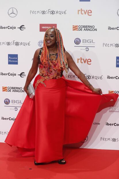 La cantante Lucrecia con un vestido rojo de falda tubo.