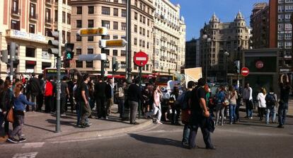 Un grupo de jóvenes corta el tráfico en el centro de Valencia.