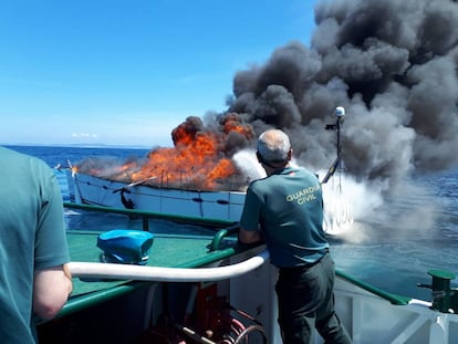 Dos agentes se aproximan al velero sueco en llamas.