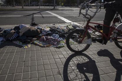 Una bicicleta del Bicing passa per davant d'una parada del 'mercat de la misèria'. Sovint el mercat és tan extens que amb prou feines s'hi pot passar amb una bicicleta o un cotxet de nen petit. I també sovint els venedors abandonen al mig del carrer part de la mercaderia que han exposat durant la jornada.