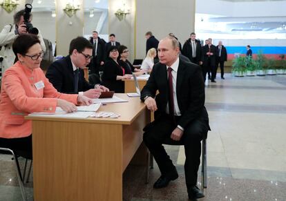 Valdimir Putin, presidente y candidato a las presidencias, obtiene sus papeletas para poder ejercer su voto en la Academia de las Ciencia de Rusia en Moscú (Rusia).
