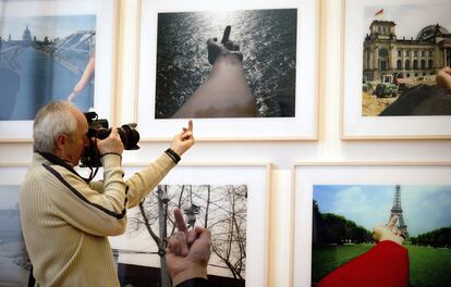 Un fotógrafo imita el gesto de la serie fonográfica "Perspective studies", del artista chino Ai Weiwei, incluida en la exposición "Evidence" que acoge el atrio de la Martin-Gropius-Bau de Berlín (Alemania).