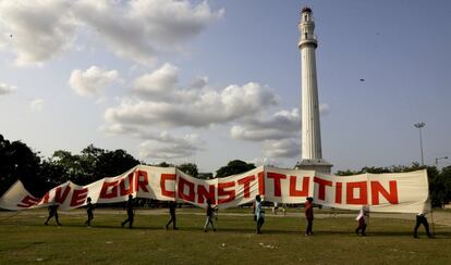 Miembros de los sindicatos de izquierdas caminan con una pancarta que lee "salva nuestra constitución" frente al monumento de la ciudad, Shaheed Minar, antes conocido como el Monumento Ochterlony, durante un mitin el 1 de mayo en Calcuta (India).