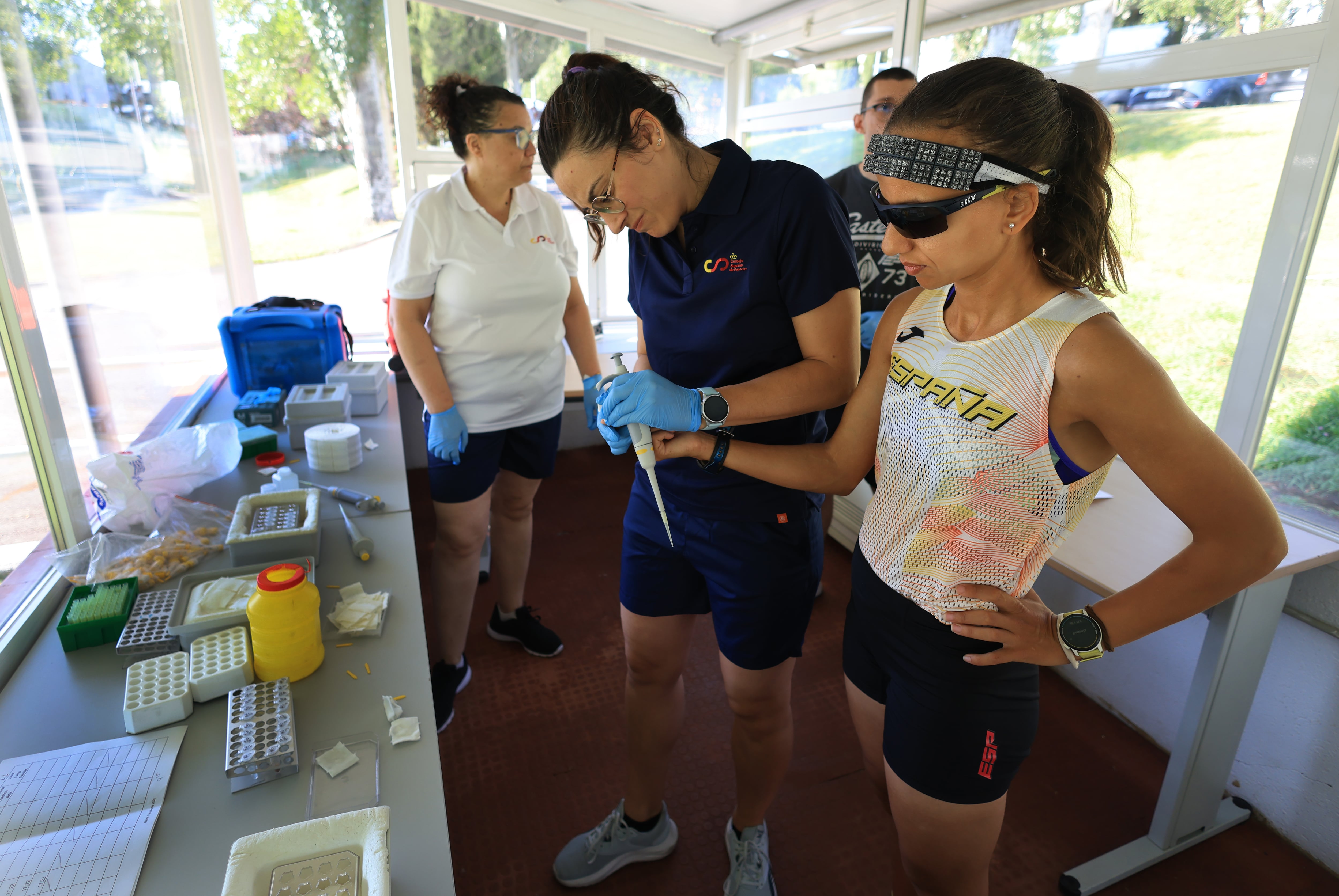 El equipo médico del Consejo Superior de Deportes midiendo la concentración de lactato en sangre de una maratoniana del equipo español que competirá en el campeonato de Europa de 2026 en Birmingham. 