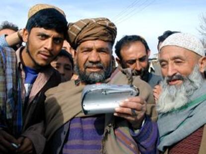 Un grupo de habitantes de Kabul, reunido hoy para escuchar un radio casette.