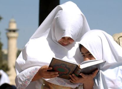 Dos muchachas musulmanas leen el Corán junto a la mezquita de Al Aqsa, en Jerusalén.