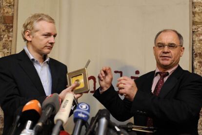 Julian Assange (izquierda) recibe de Rudolf Elmer discos con información bancaria, ayer en Londres.