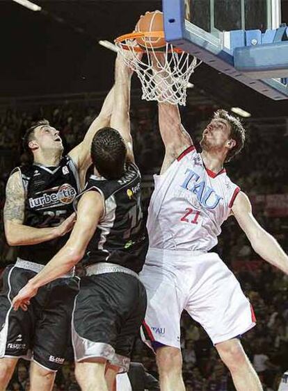 El pívot del TAU Tiago Splitter realiza un mate ante los jugadores del Iurbentia Damir Markota (izquierda) y Marko Banic.