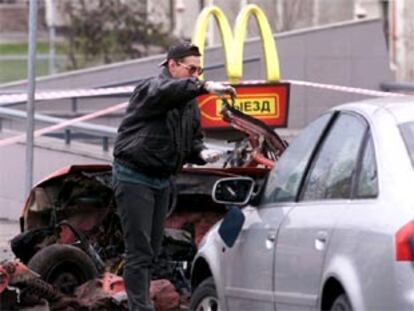 Un experto de la policía rusa inspecciona los restos del coche bomba que ayer estalló en Moscú.