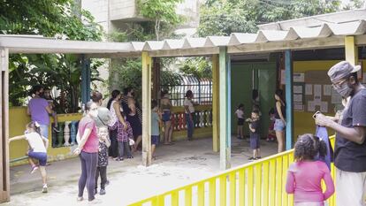 Los padres esperan a sus hijos a la salida del colegio. “Hay una lista de espera y los directores de cada centro tenemos que elegir quiénes vuelven a los centros físicamente y quienes siguen en casa. La prioridad es para los mayores, con hermanos y en situación de vulnerabilidad, según las reglas. Los padres muchas veces no están de acuerdo, entonces queda en nuestras manos gestionar ese conflicto”, explica la directora del colegio.