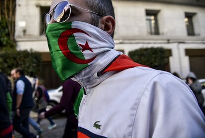 Un hombre tapado con la bandera argelina participa en la manifestación contra Buteflika en Argel.