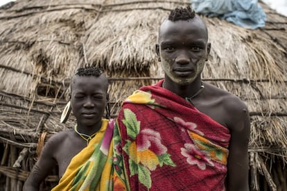 Asón, guía local del poblado Mursi de Marreke en el Parque Nacional de Mago, en el Valle del Omo, posa junto a su hermana en la cabaña familiar. Visten mantas de tejido sintético de origen chino que van sustituyendo paulatinamente a las ropas tradicionales. Como contraste y unión de nuestra metáfora visual, cada uno de ellos posa con los ojos abiertos y cerrados.