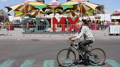 CIUDAD DE MÉXICO, 15OCTUBRE2021.- Un hombre de la tercera edad pasea sobre su bicicleta frente a la Plaza de la Constitución en donde actualmente está instalada la Feria Internacional del Libro. 
FOTO: ROGELIO MORALES /CUARTOSCURO.COM