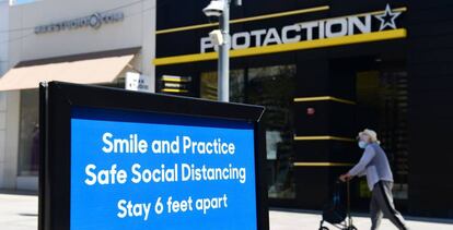 Una señal que recuerda la necesidad de tomar precauciones contra el coronavirus en una calle comercial de Santa Mónica (California).