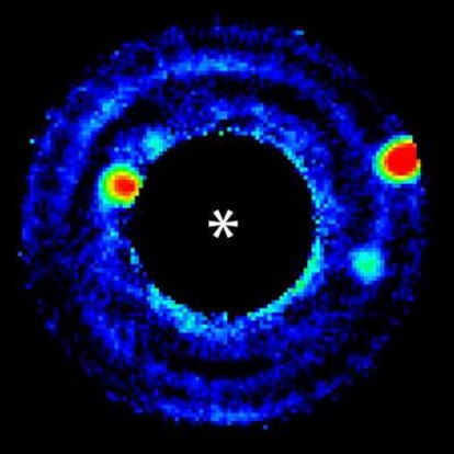 Imagen de tres planetas de distinto tamaño alrededor de una estrella, generada por láser y ocultada en el ensayo del sistema para fotografiar cuerpos del tamaño de la Tierra.