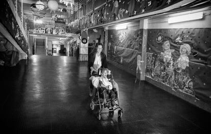 Lorenzo, acompañado por una enfermera, en el colegio de educación especial Virgen del Amparo de Guadalajara con las paredes decoradas con dibujos de estrellas, planetas, astronautas...