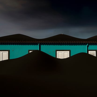 Ash from the Cumbre Vieja volcano on La Palma in Spain's Canary Islands covers a house on Nov. 1, 2021. Scientists estimate the volcano has ejected over 10,000 million cubic meters of ash, jettisoned thousands of meters into the sky. (AP Photo/Emilio Morenatti)