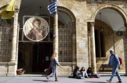 Varias personas pasan delante de la iglesia Panayia Phaneromeni en el centro de Nicosia (Chipre). La Iglesia de Chipre puso esta semana sus bienes a disposición del estado para intentar evitar el rescate de la UE.