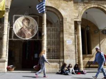 Varias personas pasan delante de la iglesia Panayia Phaneromeni en el centro de Nicosia (Chipre). La Iglesia de Chipre puso esta semana sus bienes a disposición del estado para intentar evitar el rescate de la UE.