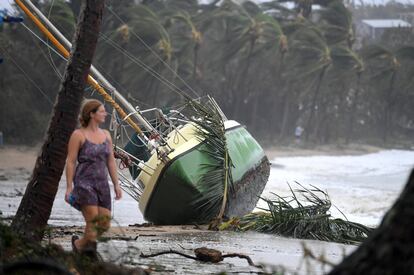 Una residente pasea cerca de un yate que fue empujado a tierra, después de que el ciclón golpeara la ciudad de Queensland, el 29 de marzo de 2017.