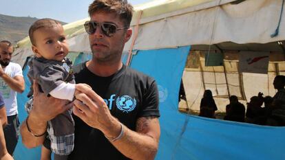 Ricky Martin junto a un bebé sirio en el campo de refugiados de Minnieh, cerca de Trípoli (Líbano).