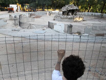 Una persona mira las obras en la fuente Campanillas, en el parque del Retiro.