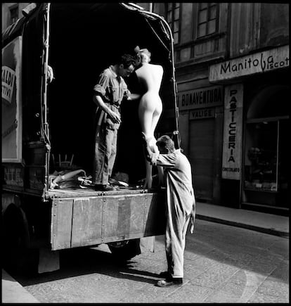 Dos trabajadores manipulan un maniquí en un camión, en Milán en 1949.