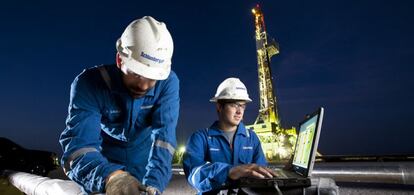 Trabajadores de Schlumberger junto a una plataforma petrol&iacute;fera. 