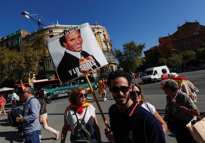 Un home porta un cartell de Julio Iglesias amb la llegenda "Puigdemont l'has cagat i ho saps".