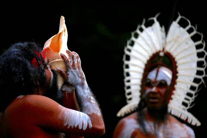 Un aborigen australiano (izquierda) sopla una concha durante la ceremonia de bienvenida a un indígena de las islas del Estrecho de Torres a la Casa del Gobierno, en Sídney (Australia).