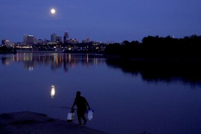 Um pescador no rio Missouri, em Kansas City, iluminado pela superlua da madrugada desta quarta-feira.