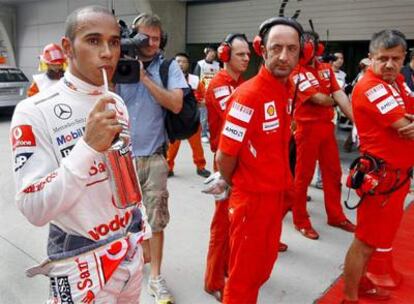 Los mecánicos de Ferrari observan a Lewis Hamilton tras la segunda sesión de entrenamientos libres celebrada ayer en Shangai.