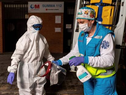 Miembros del equipo sanitario del Summa realizan el proceso de colocación y retiro de un EPI completo, durante su guardia de 24 horas en el Centro de Salud Las Águilas en Madrid.