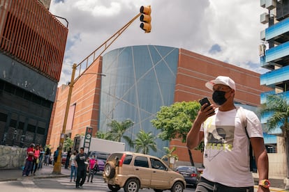 Transeúntes cruzan la calle frente a la esquina emblemática del centro comercial Sambil de La Candelaria en Caracas, Venezuela, el 19 de marzo de 2022.