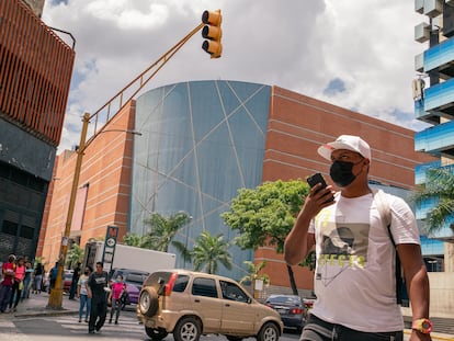 Transeúntes cruzan la calle frente a la esquina emblemática del centro comercial Sambil de La Candelaria en Caracas, Venezuela, el 19 de marzo de 2022.