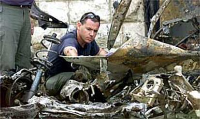 Un policía revisa los restos de uno de los dos coches bomba que explotaron ayer en el centro de Jerusalén, una de las zonas más vigiladas de Israel.