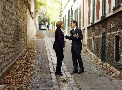 Merkel (izquierda) conversa con Sarkozy en una calle de París cuando se dirigían a un almuerzo en casa de Carla Bruni, esposa del presidente francés.