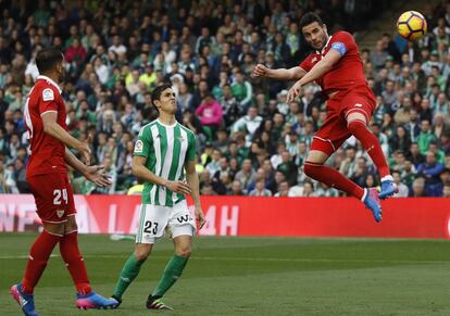 El centrocampista del Sevilla Vicente Iborra, remata un balón ante el defensa francés del Betis Aissa Mandi, durante el partido correspondiente a la vigésima cuarta jornada de Liga que disputan en el estadio Benito Villamarían de Sevilla.