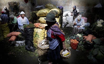 Una mujer transporta alimentos en el interior del mercado de San Roque.