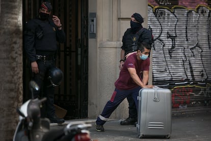 Un operario retira pertenencias de una familia desahuciada la semana pasada en Barcelona.