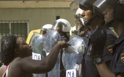 Una ciudadana nigeriana se dirige a varios efectivos antidisturbios de la Policía Nacional durante los enfrentamientos en barrio Son Gotleu, en Palma de Mallorca.