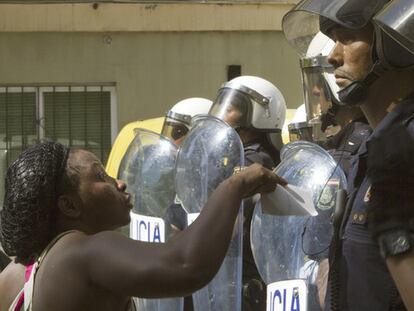 Una ciudadana nigeriana se dirige a varios efectivos antidisturbios de la Policía Nacional durante los enfrentamientos en barrio Son Gotleu, en Palma de Mallorca.