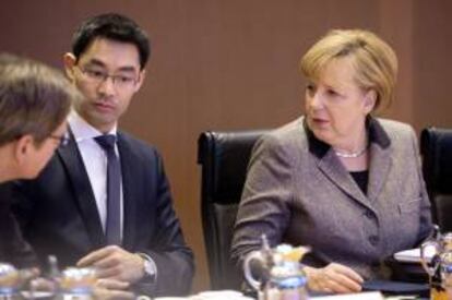La canciller alemana, Angela Merkel (dcha), conversa con el ministro de Economía, Philipp Rösler (2º izq), y con el responsable de Exteriores, Guido Westerwelle (dcha), durante la reunión semanal del Consejo de Ministros en la Cancillería en Berlín (Alemania). EFE/Archivo